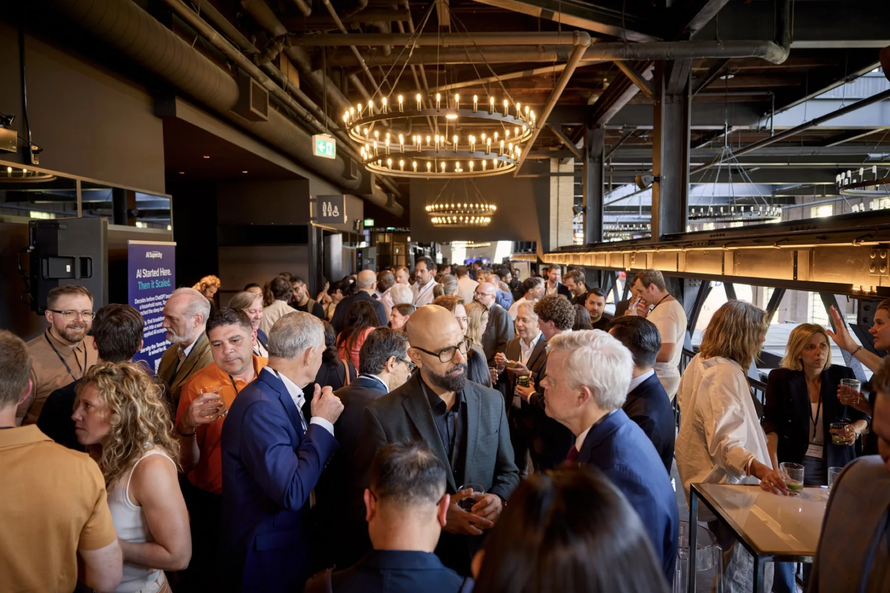 Guests networking beneath the chandeliers at Waterworks
